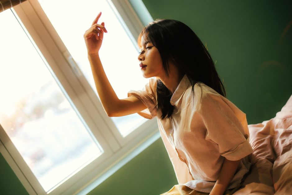잠에서 깬 후 새벽 꿈의 잔상으로 묘한 기분을 느끼는 사람의 모습.